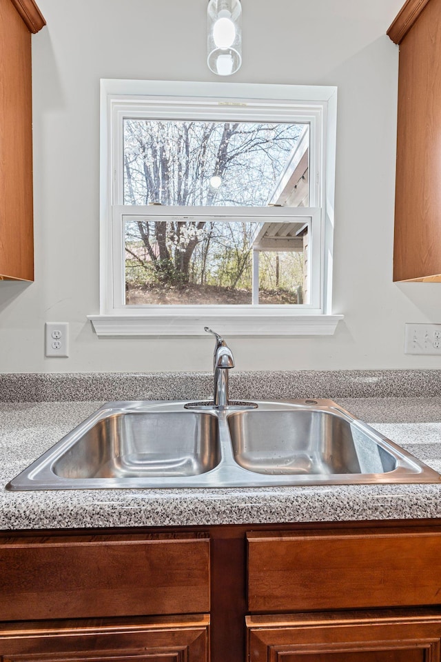 room details with a sink, brown cabinetry, and light countertops