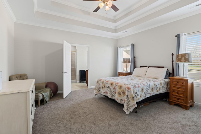 bedroom featuring a tray ceiling, ornamental molding, visible vents, and light carpet