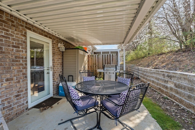 view of patio featuring a grill, outdoor dining area, and fence