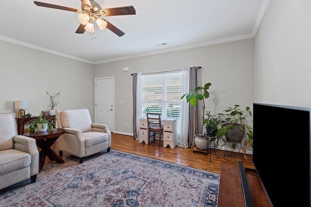 sitting room with visible vents, baseboards, ceiling fan, ornamental molding, and wood finished floors