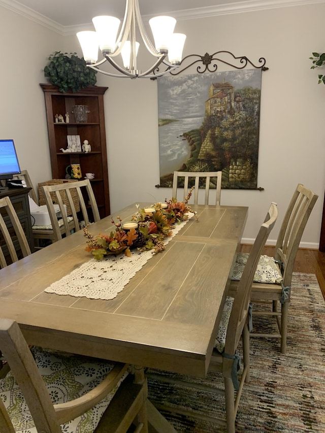 dining room with crown molding, wood finished floors, and a chandelier