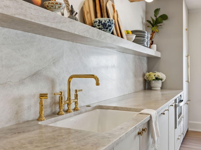 interior space with white cabinetry, light countertops, and a sink