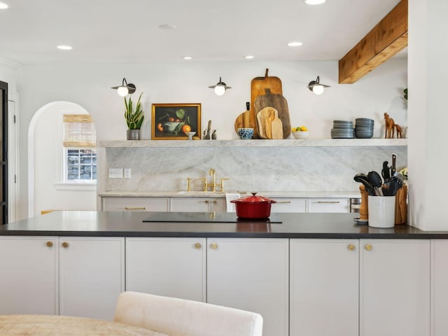 kitchen featuring dark countertops, white cabinets, and a sink