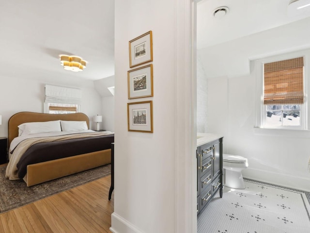 bedroom featuring baseboards and wood finished floors