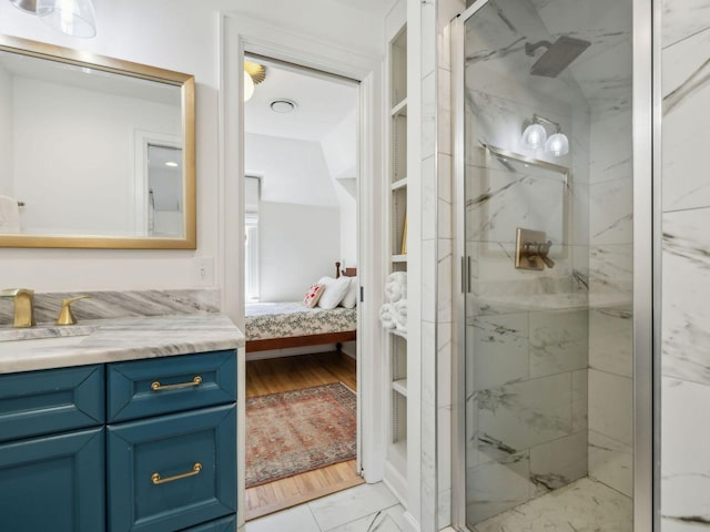 ensuite bathroom featuring a marble finish shower, marble finish floor, connected bathroom, and vanity