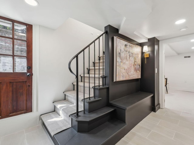 staircase featuring visible vents and recessed lighting