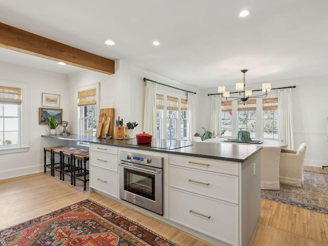 kitchen with a notable chandelier, plenty of natural light, and stainless steel oven