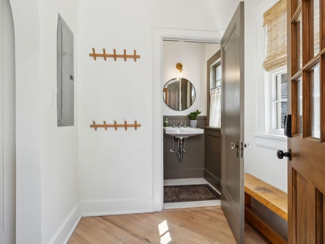 bathroom with electric panel, baseboards, and wood finished floors