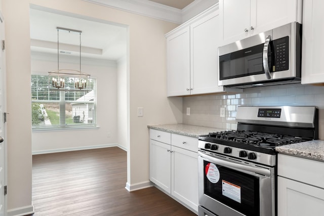 kitchen featuring an inviting chandelier, backsplash, appliances with stainless steel finishes, and ornamental molding