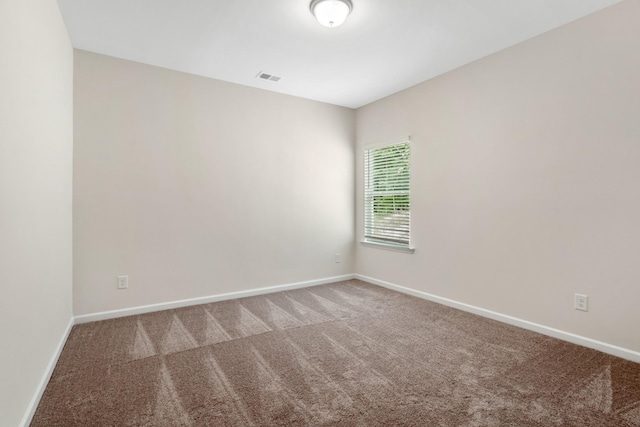 spare room with visible vents, baseboards, and carpet flooring