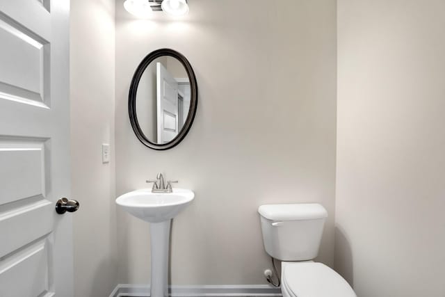 bathroom featuring toilet and baseboards