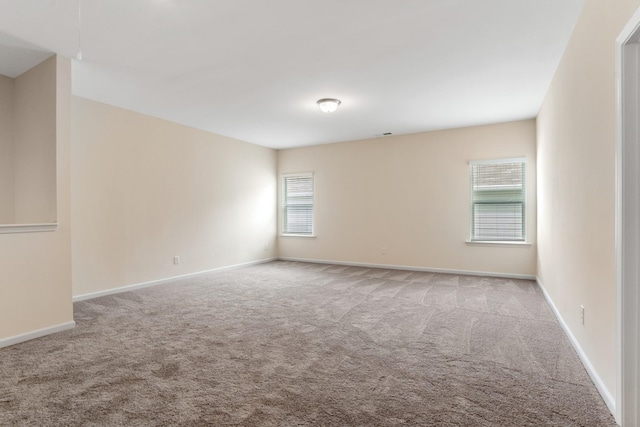 unfurnished room with carpet and baseboards