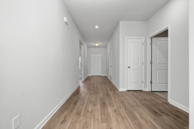 hallway with baseboards and light wood-style floors