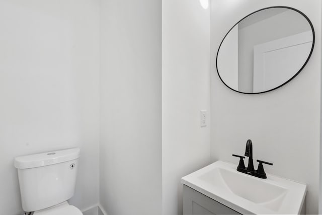 half bath featuring vanity and toilet