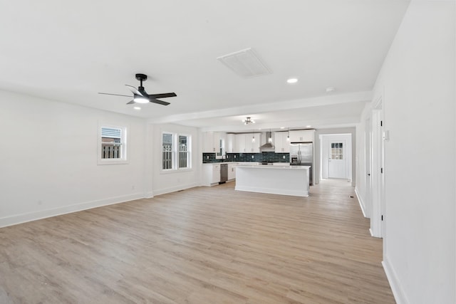 unfurnished living room with recessed lighting, baseboards, light wood finished floors, and ceiling fan