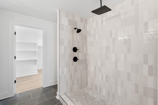 bathroom featuring tile patterned floors, baseboards, and a tile shower