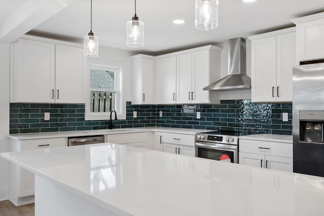 kitchen featuring decorative light fixtures, light countertops, decorative backsplash, stainless steel appliances, and wall chimney exhaust hood