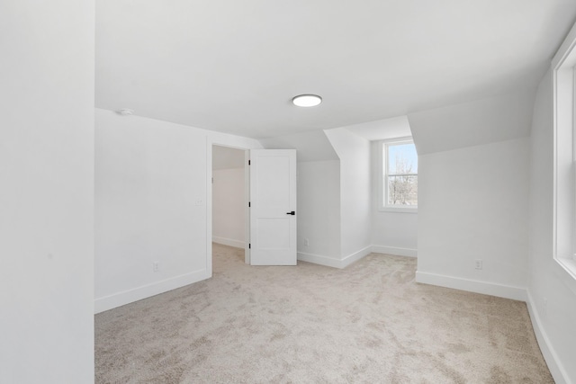 interior space featuring lofted ceiling, carpet flooring, and baseboards