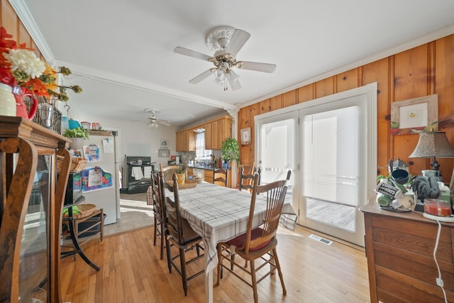 dining space featuring visible vents, ceiling fan, crown molding, and light wood finished floors