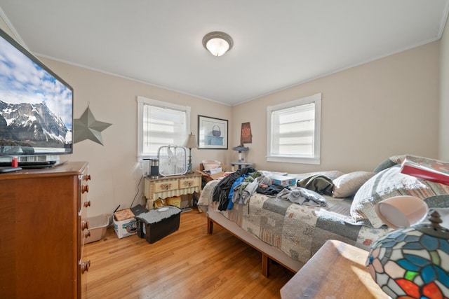 bedroom featuring crown molding, multiple windows, and wood finished floors