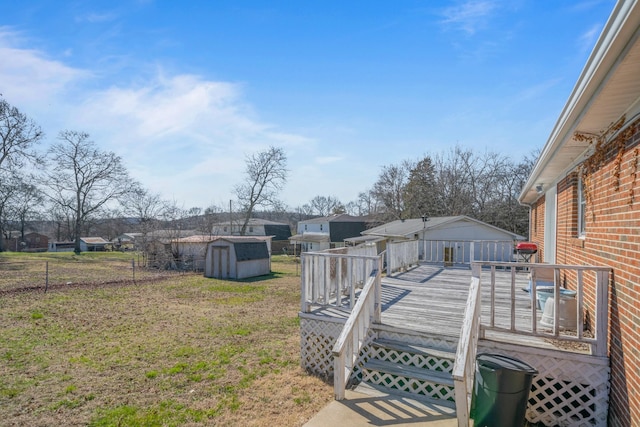 view of yard with an outbuilding, a shed, a wooden deck, and fence