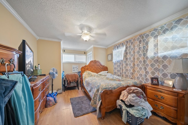 bedroom with crown molding, a textured ceiling, light wood-type flooring, and ceiling fan