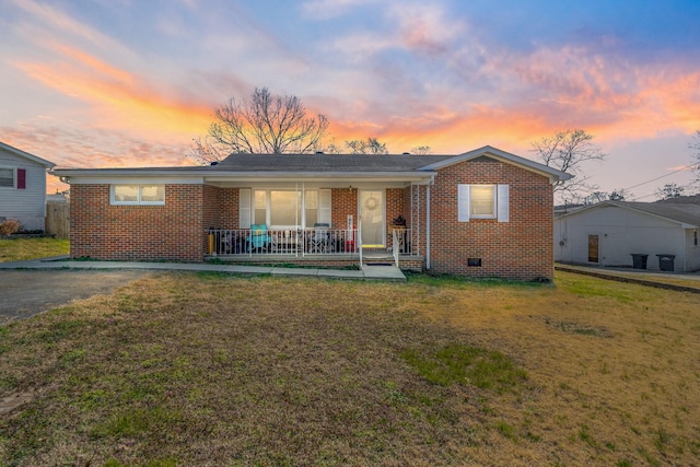 view of front of property featuring brick siding, crawl space, a porch, and a front yard