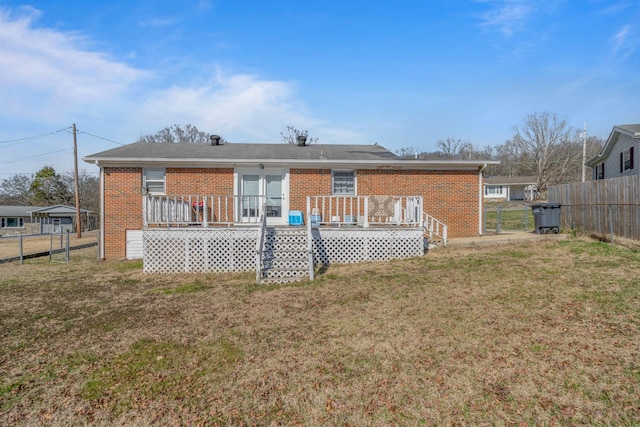 back of property featuring a yard, brick siding, and fence