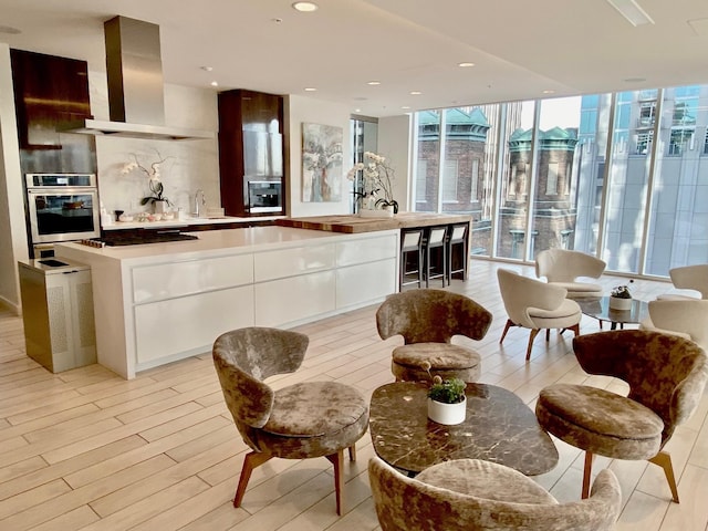 515 Church St Unit 3408, Nashville, TN 37219 - kitchen featuring a wall of windows, island exhaust hood, oven, white cabinetry, and modern cabinets