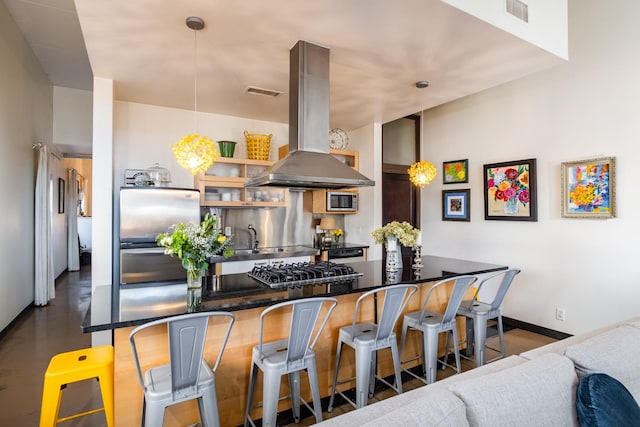 kitchen with dark countertops, visible vents, a kitchen bar, island range hood, and stainless steel appliances