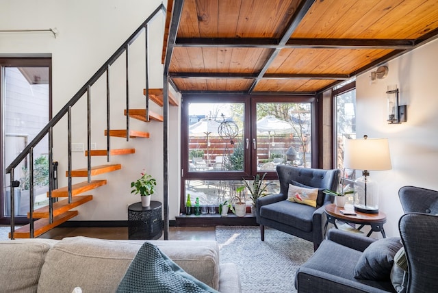 living area featuring a wall of windows, stairway, wood ceiling, and beamed ceiling