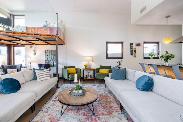 living area with visible vents, a healthy amount of sunlight, and wood finished floors