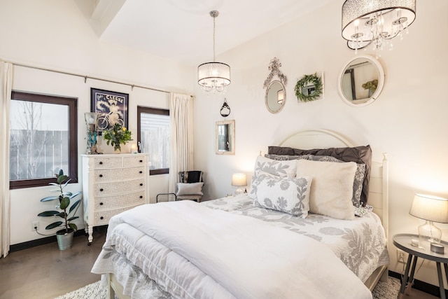 bedroom with concrete floors, baseboards, and an inviting chandelier