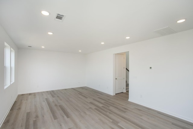 empty room featuring recessed lighting, light wood-style floors, visible vents, and baseboards