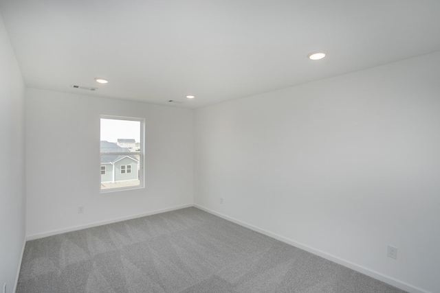 carpeted spare room featuring visible vents, recessed lighting, and baseboards