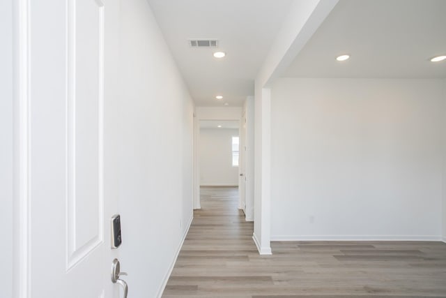 hallway featuring visible vents, recessed lighting, light wood-type flooring, and baseboards