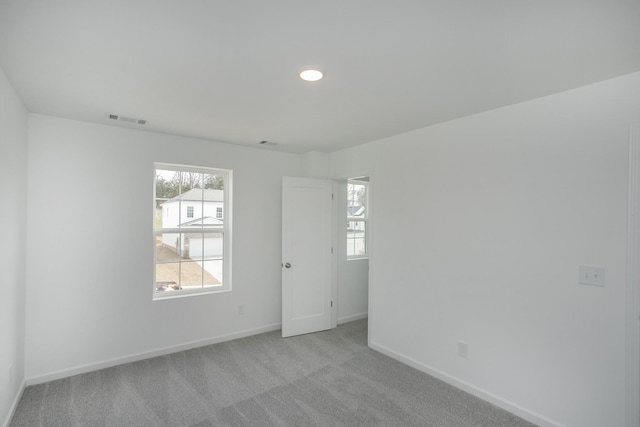 unfurnished room with carpet flooring, baseboards, and visible vents