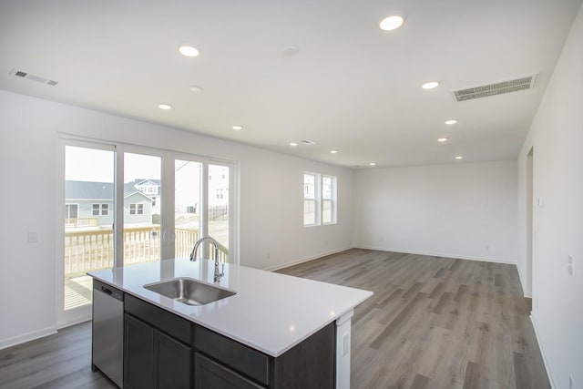 kitchen featuring stainless steel dishwasher, light wood-style floors, visible vents, and a sink