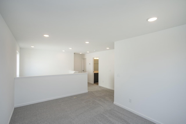 spare room with recessed lighting, baseboards, and light colored carpet