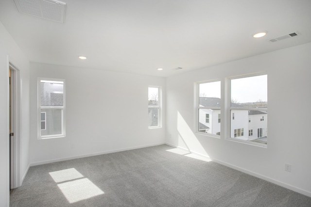 carpeted spare room featuring recessed lighting, visible vents, and baseboards