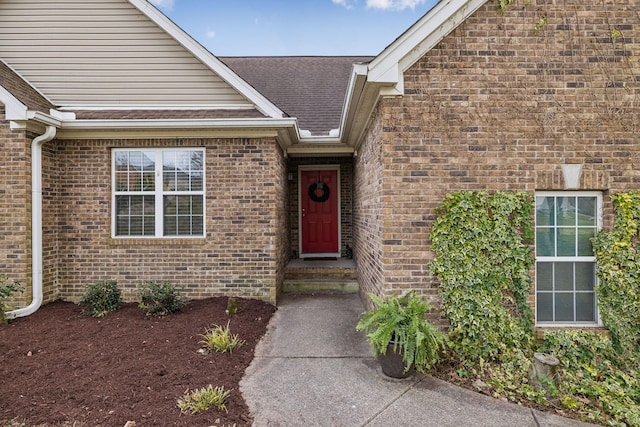 entrance to property with brick siding and roof with shingles