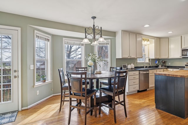 dining room with an inviting chandelier, recessed lighting, light wood-style floors, and baseboards