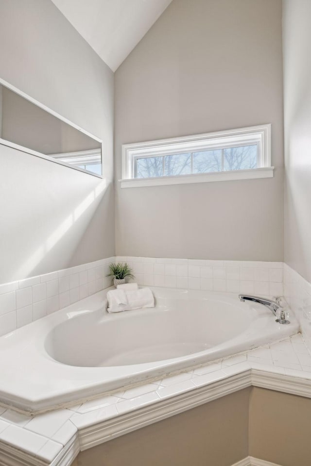 bathroom with lofted ceiling and a garden tub