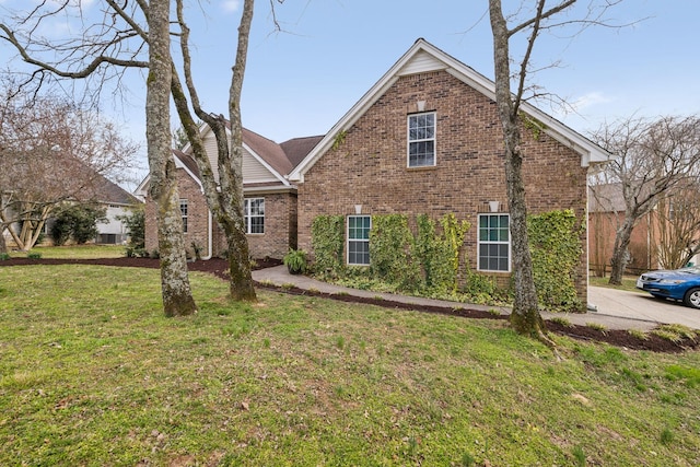 view of front facade with brick siding and a front yard