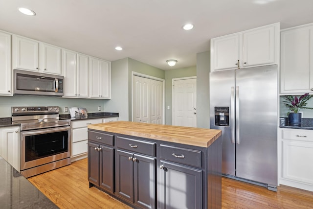 kitchen featuring appliances with stainless steel finishes, butcher block counters, and white cabinetry