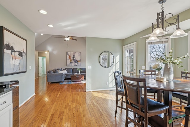 dining area with vaulted ceiling, light wood-style flooring, baseboards, and ceiling fan