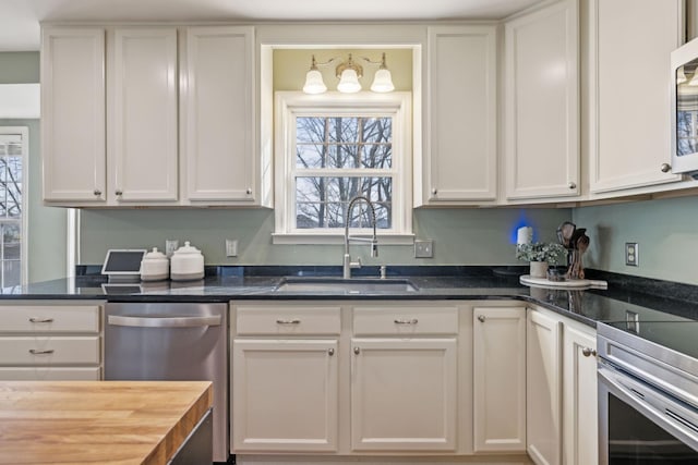 kitchen featuring a sink, stainless steel appliances, and white cabinetry