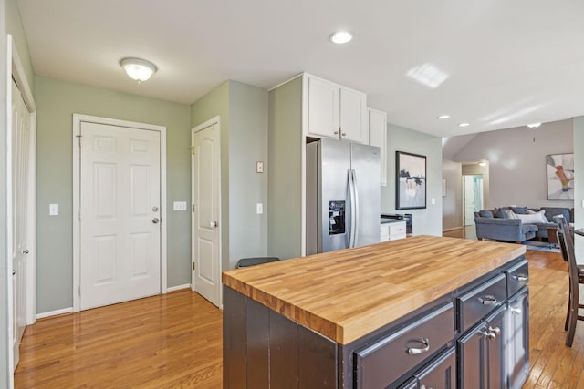 kitchen featuring light wood finished floors, wooden counters, stainless steel fridge with ice dispenser, recessed lighting, and white cabinets