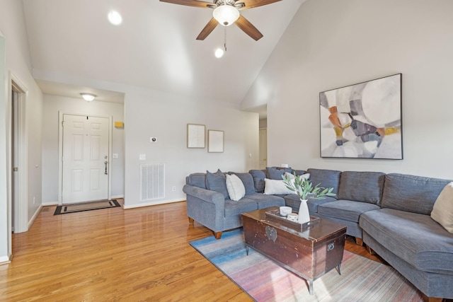 living room featuring light wood-type flooring, visible vents, baseboards, and ceiling fan