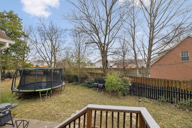 view of yard with a trampoline and a fenced backyard